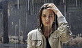 young woman standing under the rain
